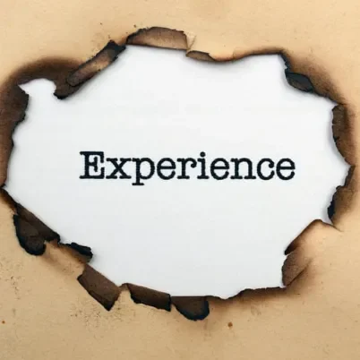 Texte "Experience" sur un fond brûlé en papier.